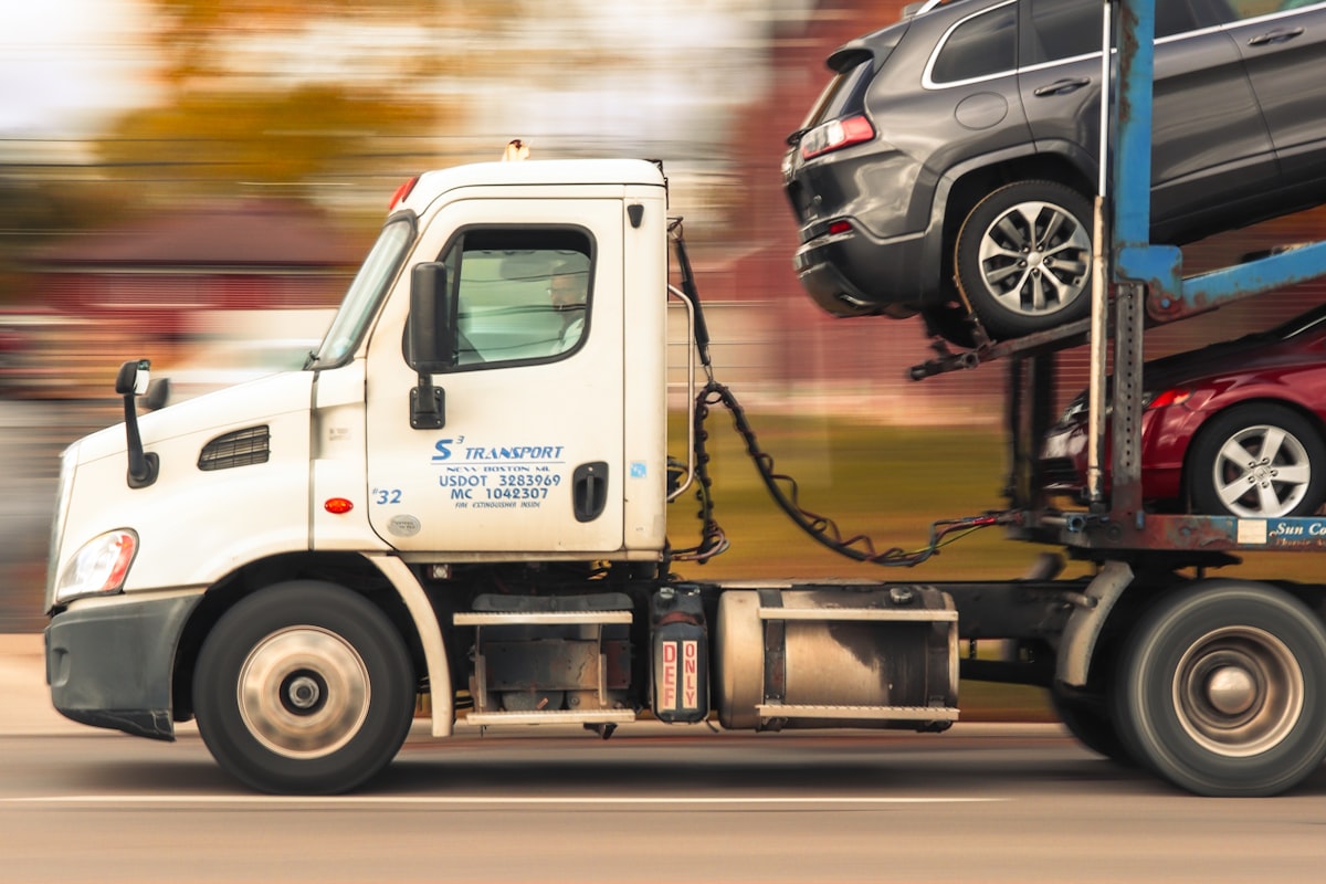 Car transporter carrying vehicles on a UK road, illustrating car transport costs
